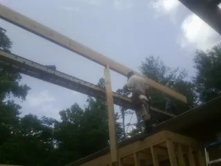 Carpenter setting a ridge beam over a new addition frame — Ice Dam Removal by Roofing Brothers in Nappanee