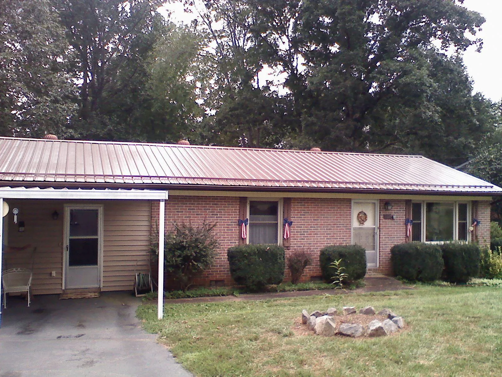 Bronze metal roof and carport on a brick ranch home — Roof Repair work by our crew in Nappanee